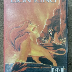 The Lion King Sega Mega Drive game box showing Simba roaring with Scar and hyenas, used condition with worn edges.